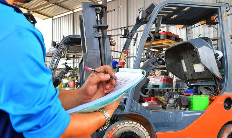 Técnico realizando inspeção preventiva em empilhadeira